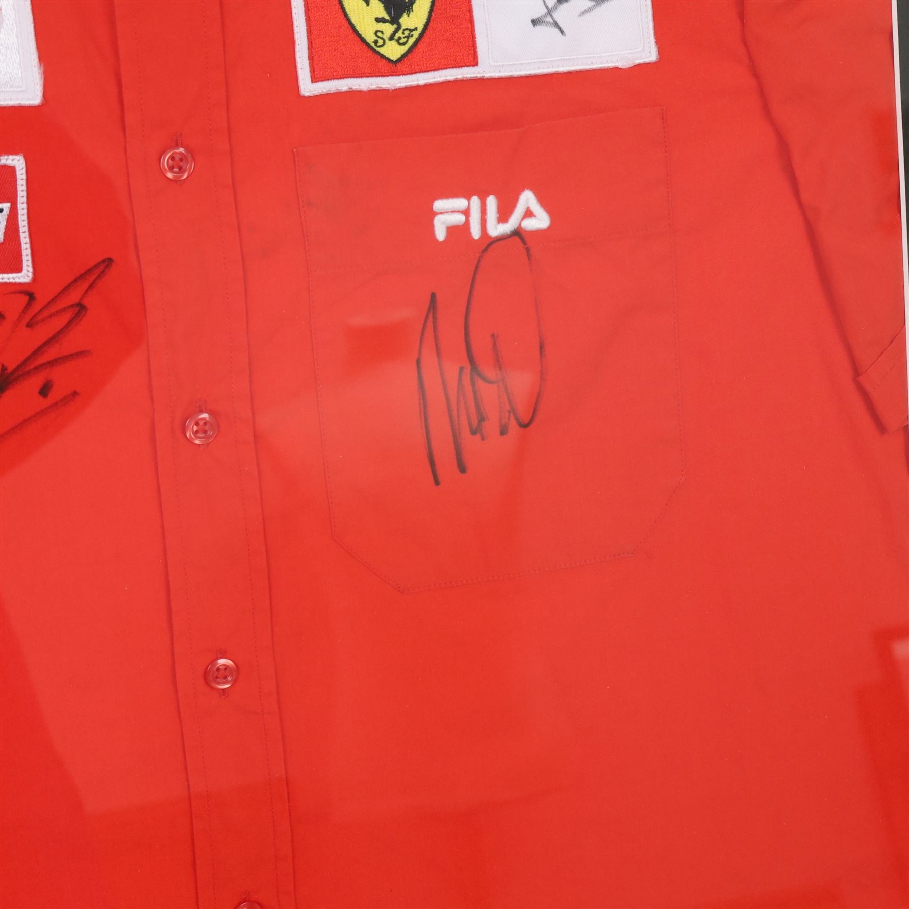 Scuderia Ferrari 2004 shirt, bearing four signatures including Michael Schumacher and Rubens Barrichello, to commemorate five consecutive World Championship wins, in glazed frame, frame H85cm