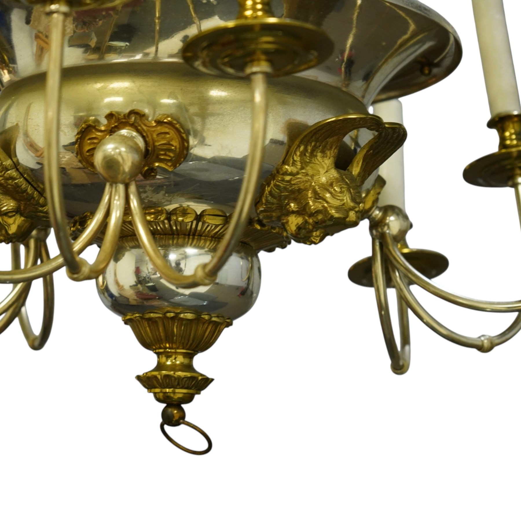 Regency Revival chromium-plated and gilt-brass nine-light chandelier of Neoclassical design, the dished central bowl applied with substantial gilt winged cherub-mask mounts and issuing nine scrolling branches with circular drip pans and faux candle sleeves, over a spherical terminal with gilt-metal gadrooned flower-petal collar and ring, max. diameter 75cm