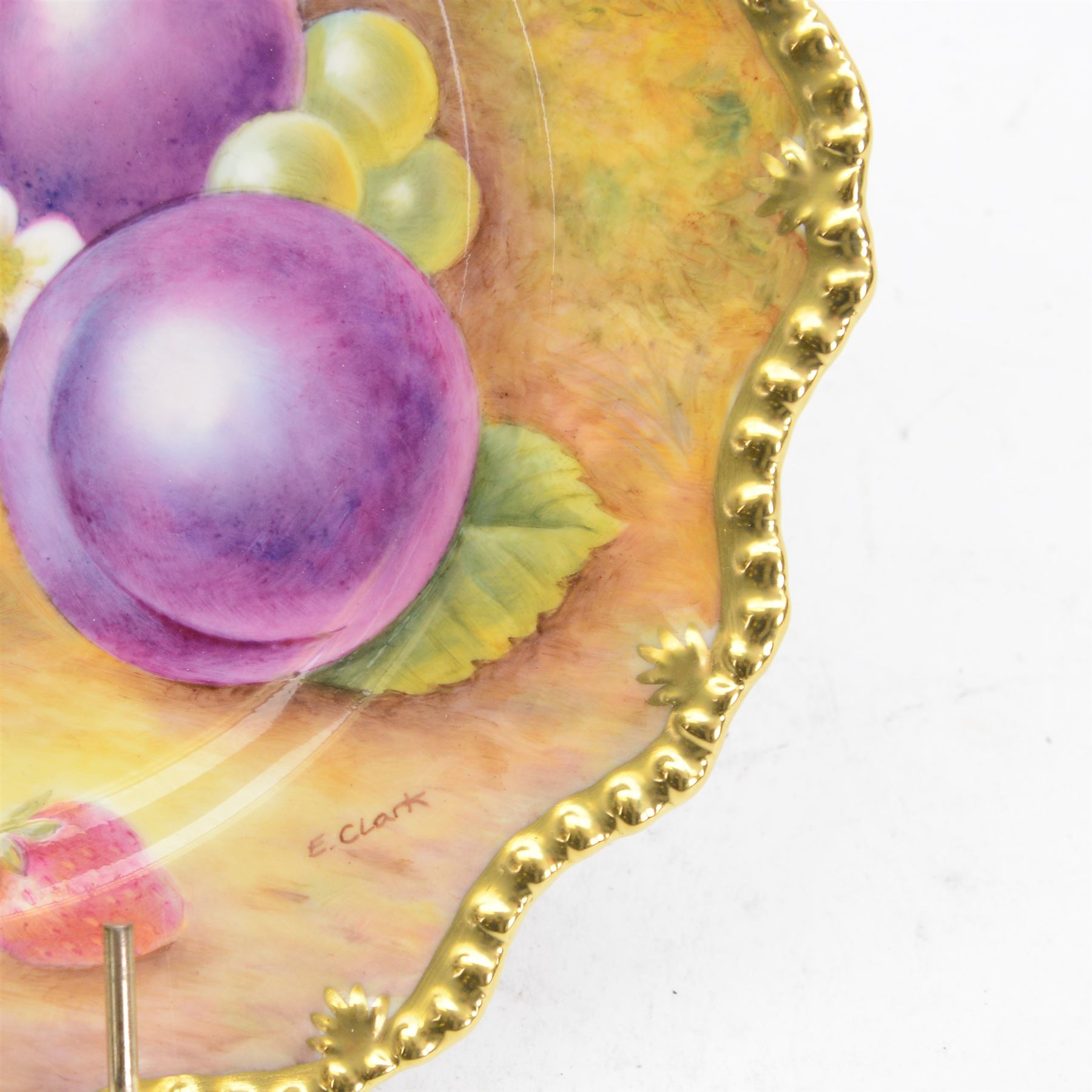 Late 20th century Royal Worcester star plate, of circular form with shaped with gilt shaped rim, hand painted by E Clark with still life of fruit upon mossy ground, signed E Clarke, with marks beneath including limited edition no 28/100, with makers fitted card box, D23cm
