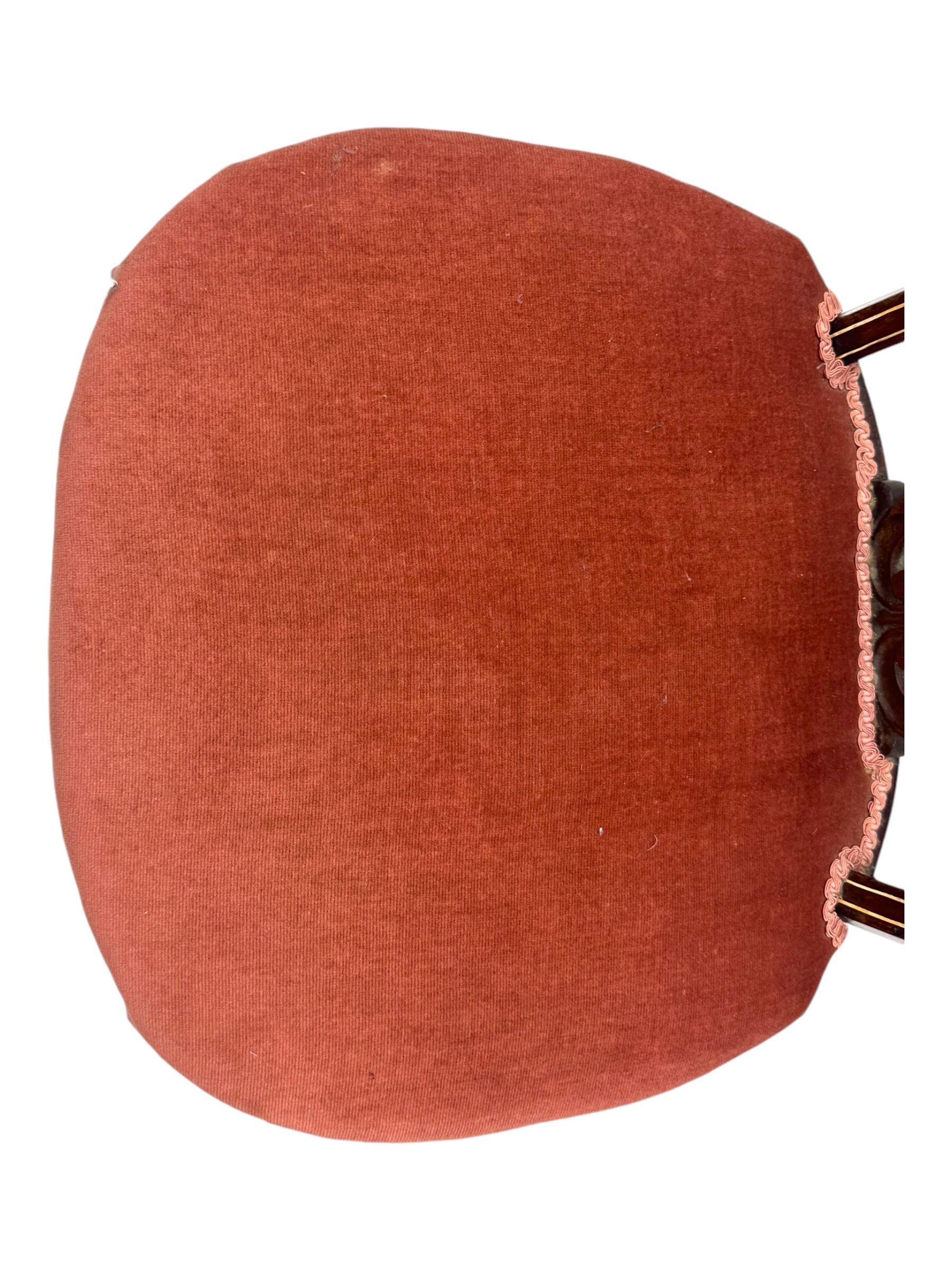 Pair of Edwardian inlaid rosewood salon chairs, upholstered in dusky pink fabric with gimp trim, oval backrest with carved crest rail with central shell motif and pierced splat, on cabriole supports terminating in castors