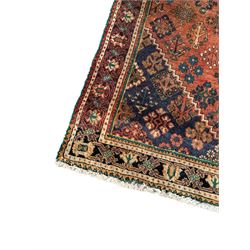 Persian Joshaghan rust ground rug, stepped lozenge medallion surrounded by repeating foliate lozenge motifs, the border decorated with stylised plant motifs, within geometric guard stripes

