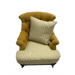 Victorian style armchair, upholstered in buttoned fabric with contrasting foliate pattern seat and scatter cushion, on turned front feet with castors