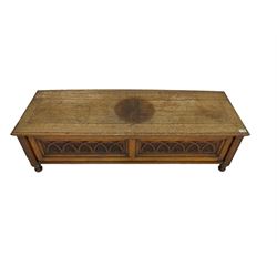 Early 20th century oak ‘bay window’ shaped blanket chest or coffer, hinged top, the front with two lunette carved panels flanked by fluted uprights, on turned feet