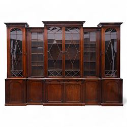 Large Georgian mahogany library bookcase, projecting moulded cornice with row of globular mounts, adjustable shelving enclosed by six astragal glazed doors, fitted with two slides and six panelled cupboard doors, two banks of five drawers, on moulded plinth base; together with two pairs of associated astragal glazed doors in mahogany, from the same property (W55.5cm x H168cm & W48cm x 168cm)