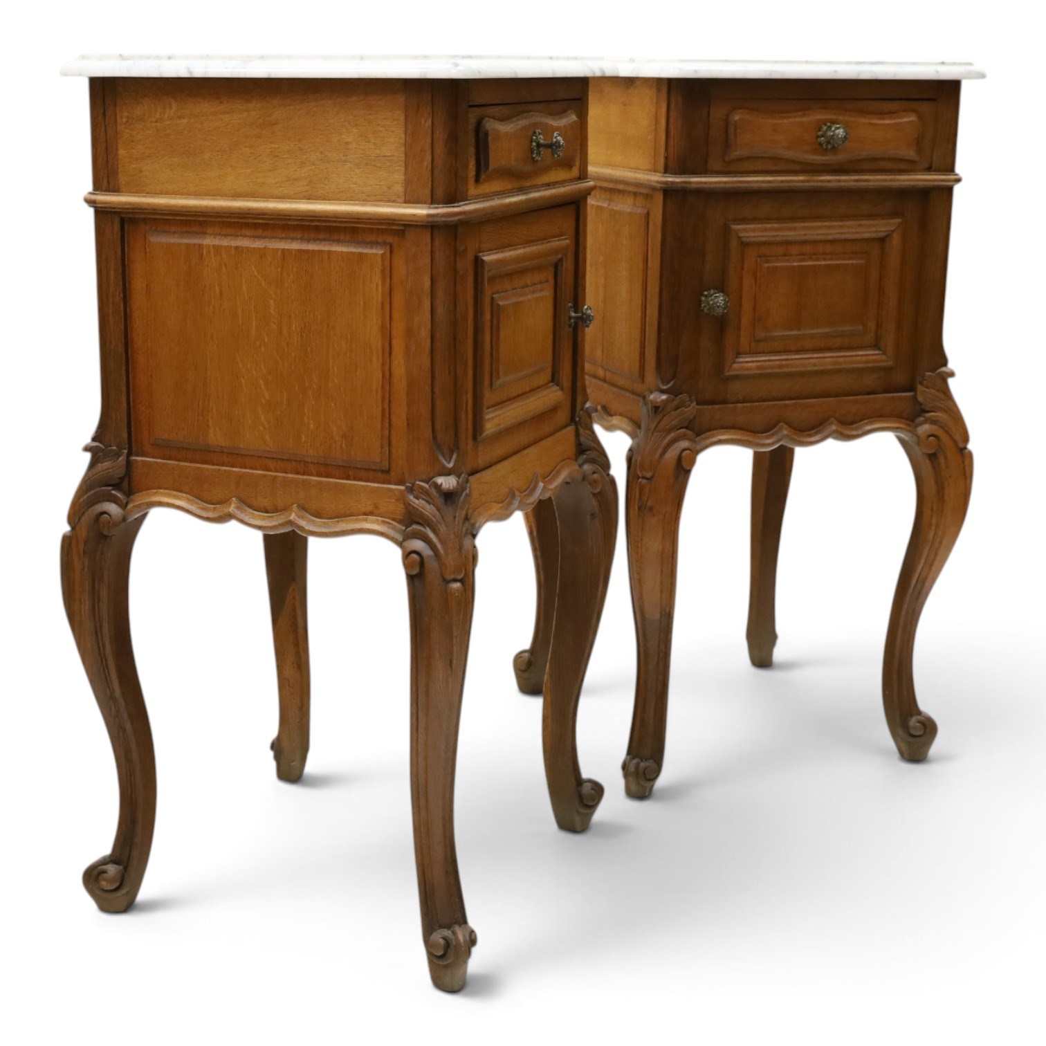 Pair of 20th century French honey oak and marble bedside cabinets, the square marble top with moulded edge, fitted with single drawer over panelled cupboard, shaped and moulded apron over scrolling acanthus leaf applied knees terminating to cabriole legs with scroll feet
