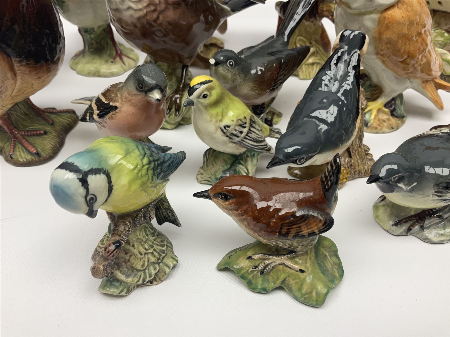 Collection twenty one of Beswick bird figures, to include Lapwing no 2416, Kingfisher no 2671, Red Pigeon 1383, Cuckoo no 2315, Nuthatch no 2418 etc