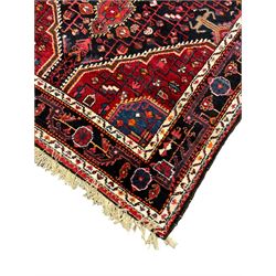 Persian Hamadan red and indigo ground rug, central lozenge medallion with extending poles, the field decorated with interlaced branches and flowerheads, guarded border with stylised floral motifs