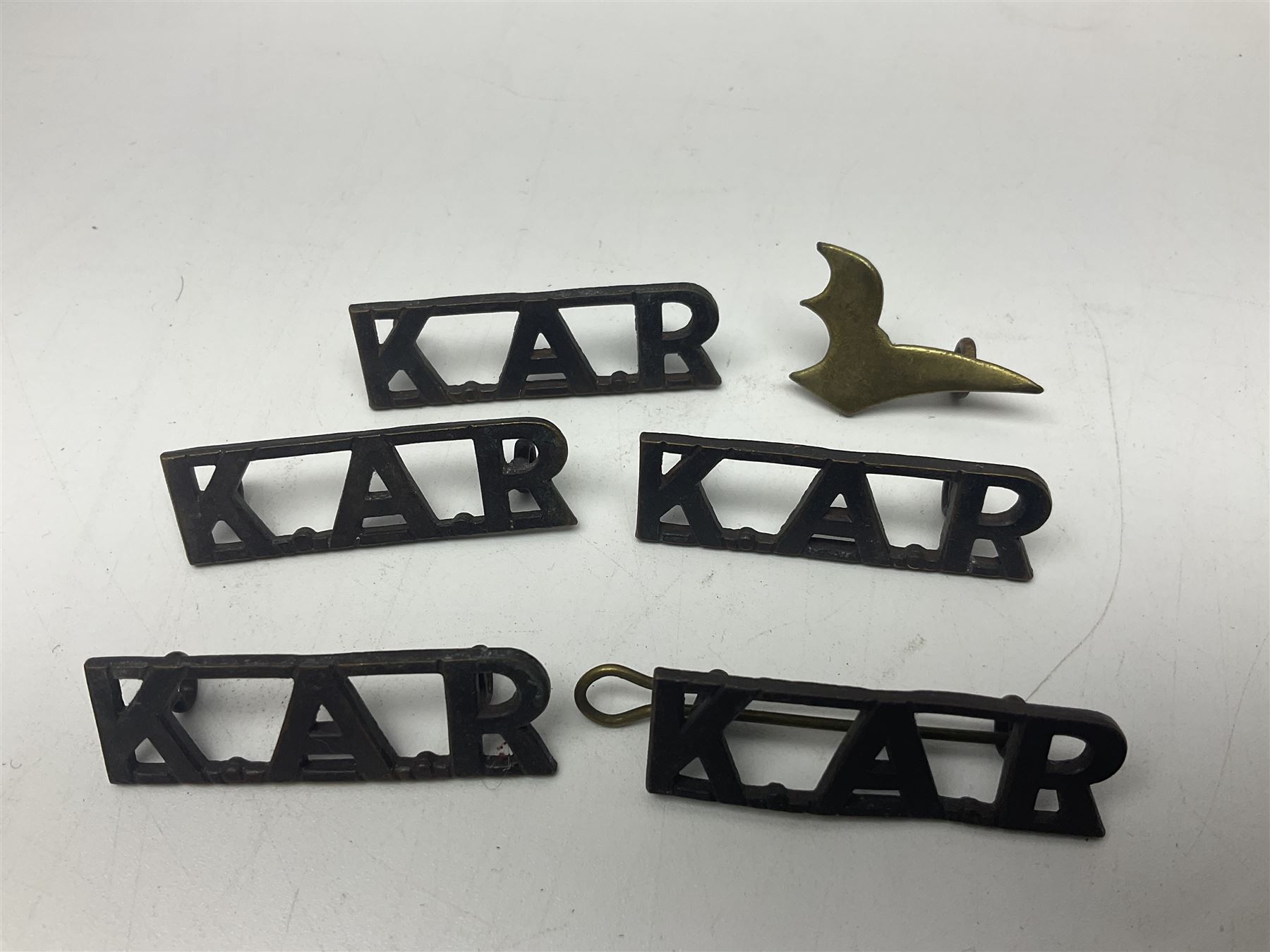 Over thirty British and Continental military metal badges; together with quantity of shoulder titles, collar dogs, rank pips, uniform buttons etc