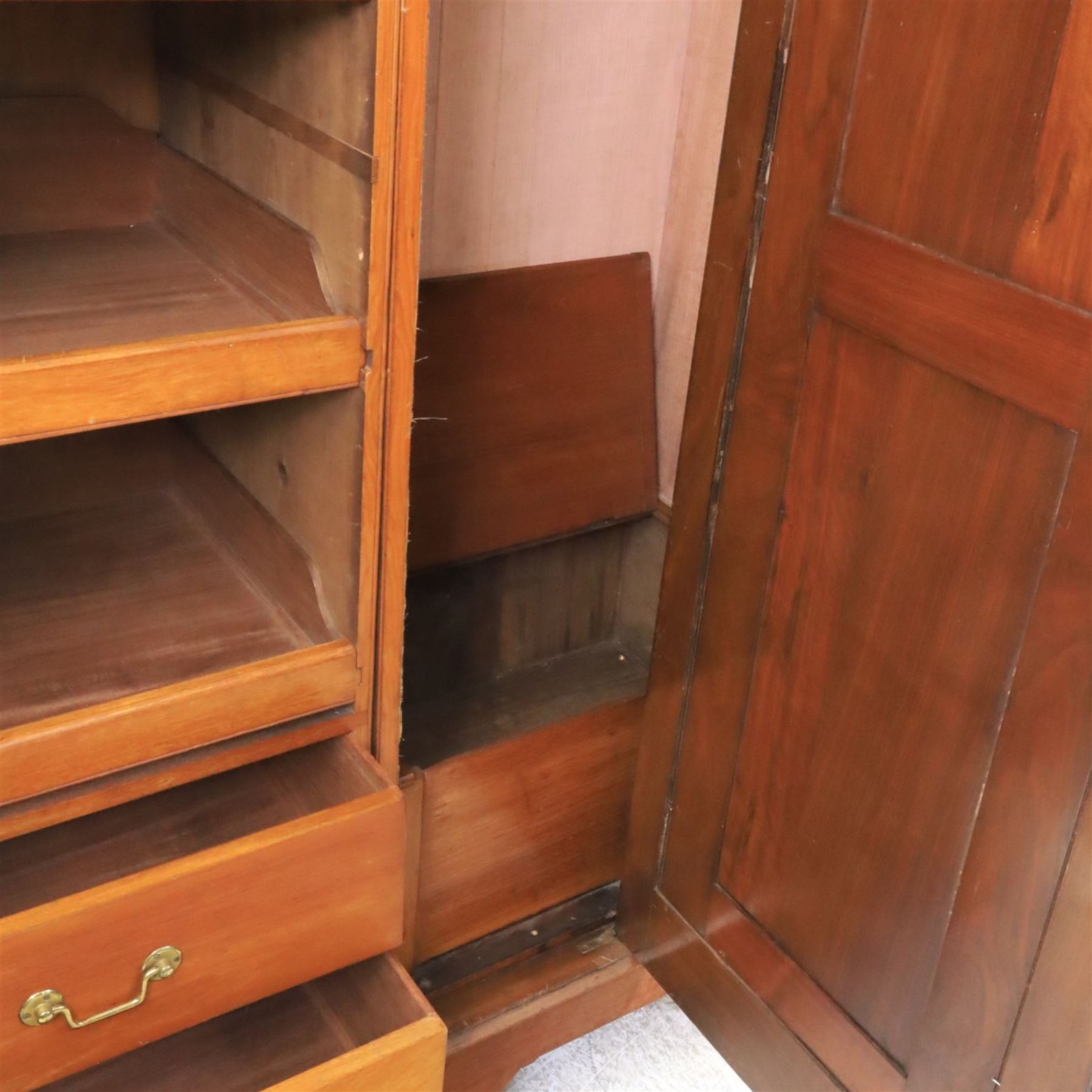 Aesthetic Movement walnut parcel gilt wardrobe, the crenellated top, above central mirrored door opening to reveal hanging space, four opened and two closed draws