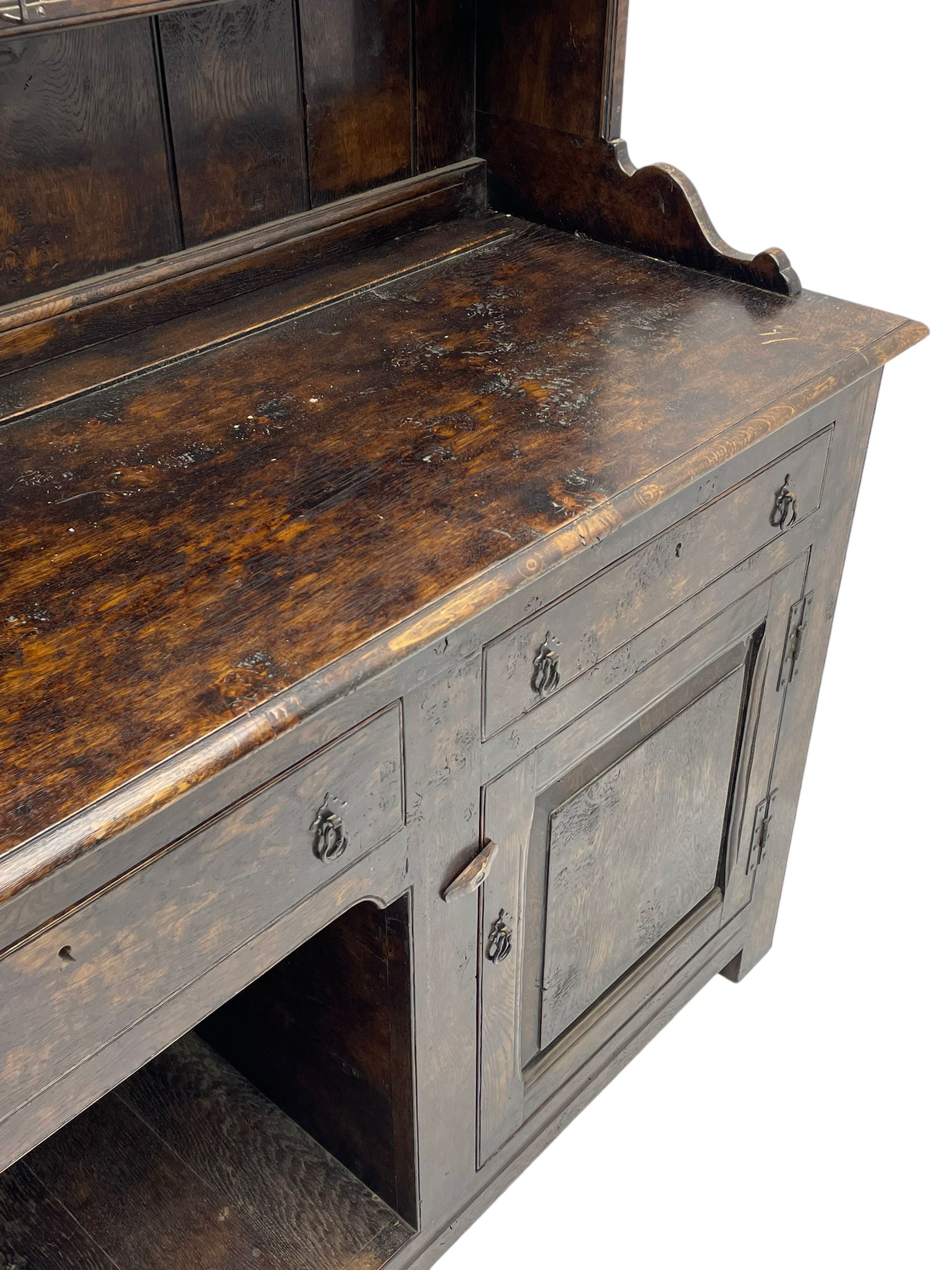 Bylaws of Leominster - 18th century design figured oak dog kennel dresser, the raised plate rack with projecting cornice over hooks and three tiers, moulded rectangular top over three drawers and two panelled cupboards, moulded frame and panelled sides, on stile supports