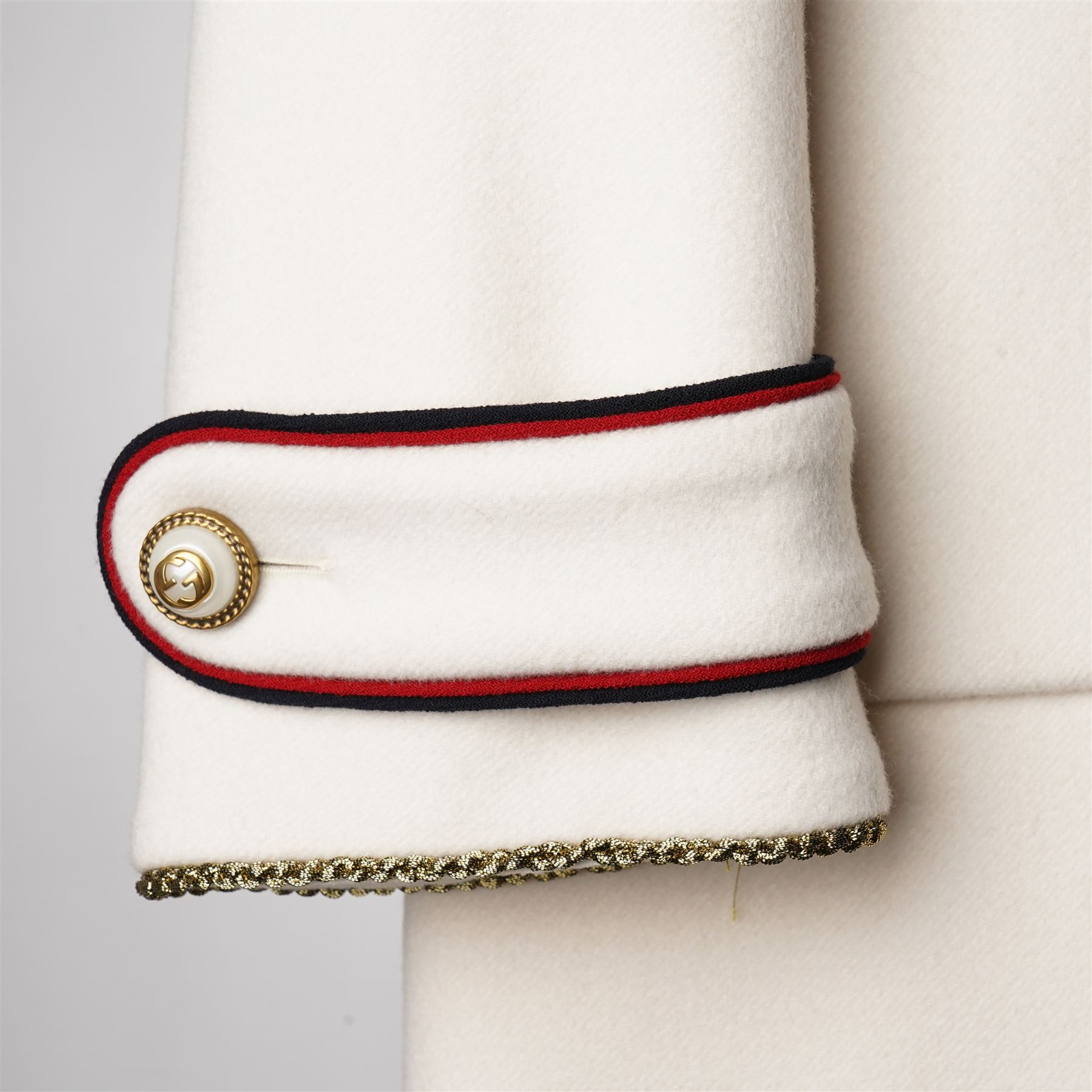 Gucci - bee embroidered wool single-breasted military coat, from the Autumn/Winter 2017 collection under Alessandro Michele, in ivory, with stand collar, red and navy trim, pearlescent and gold-tone button fastening and embroidered bee detailing to the collar, size 14, unused with original garment bag and tags