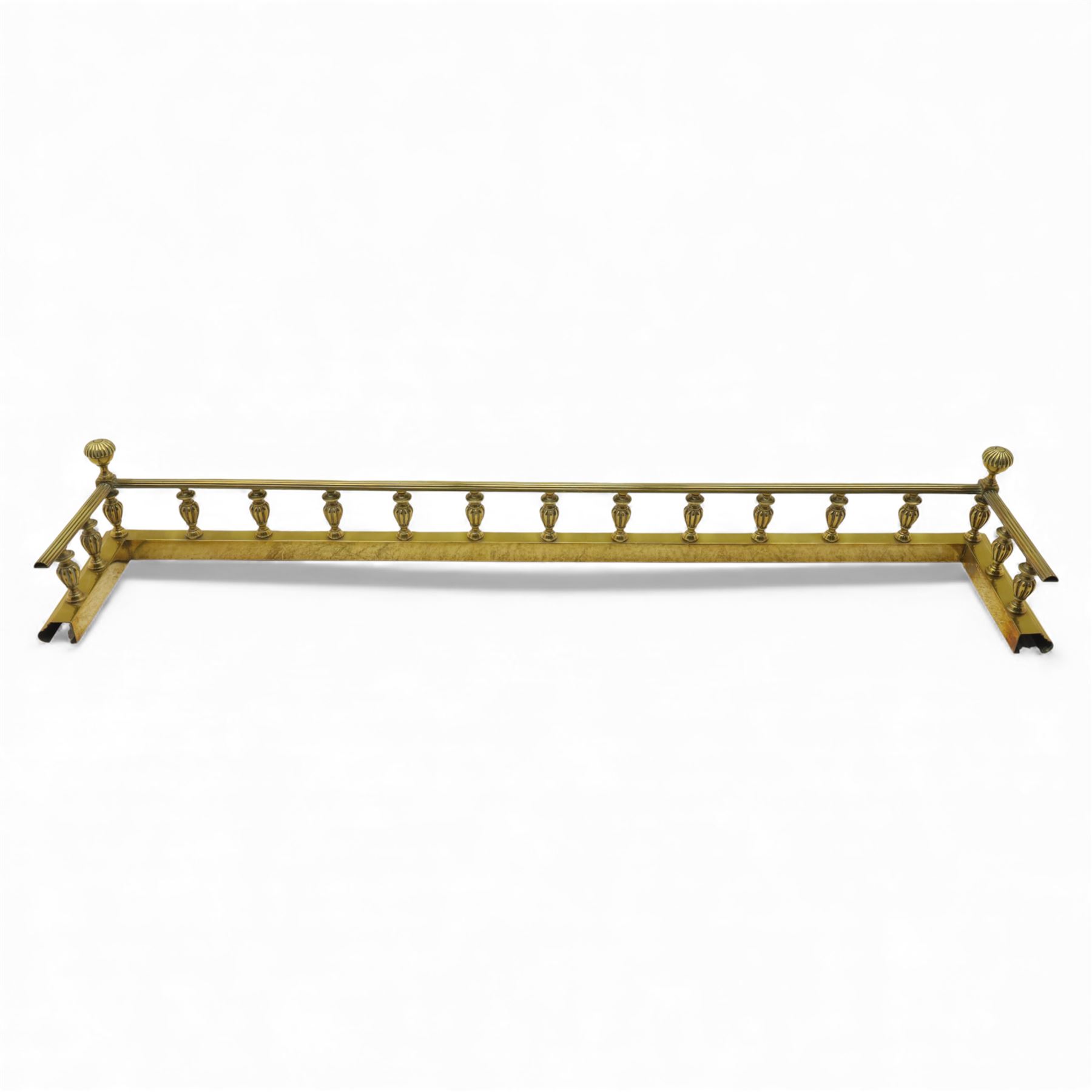 Edwardian brass fire kerb, with reeded and stepped base supporting baluster uprights and reeded top 