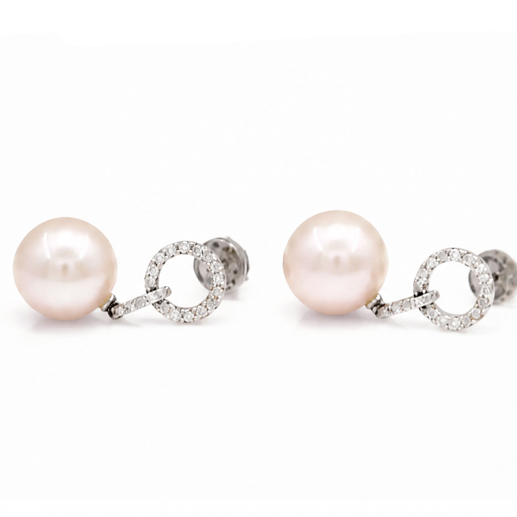 Pair of 18ct white gold pearl and diamond pedant earrings, each stud set with a halo of round cut diamonds, suspending further diamonds and a single peach / pink pearl, stamped 750