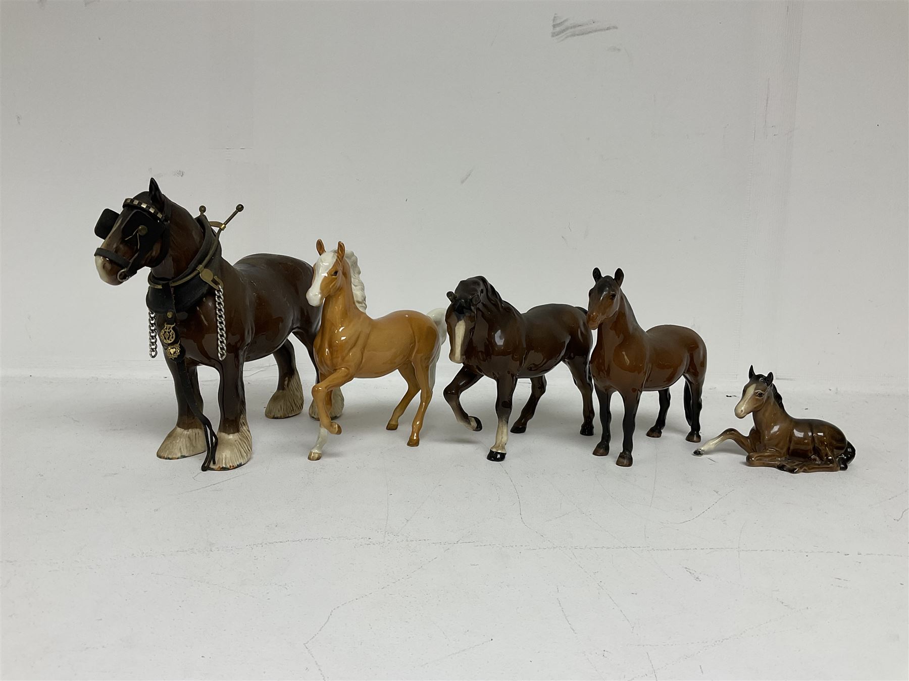 Group of Beswick figures of horses, to include a Palomino horse, Bay Shire horse, recumbent bay foal etc, all with printed marks beneath (5)