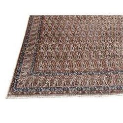 Persian Kirman carpet, the ivory ground field and border decorated with repeating Boteh motifs, interspaced with all-over floral design, blue ground border guards, the top border with signature panel