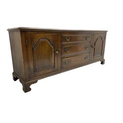 17th century design oak sideboard, moulded rectangular top over removable central panel in the form of three false drawers, two flanking cupboards enclosed by panelled doors, on bracket feet