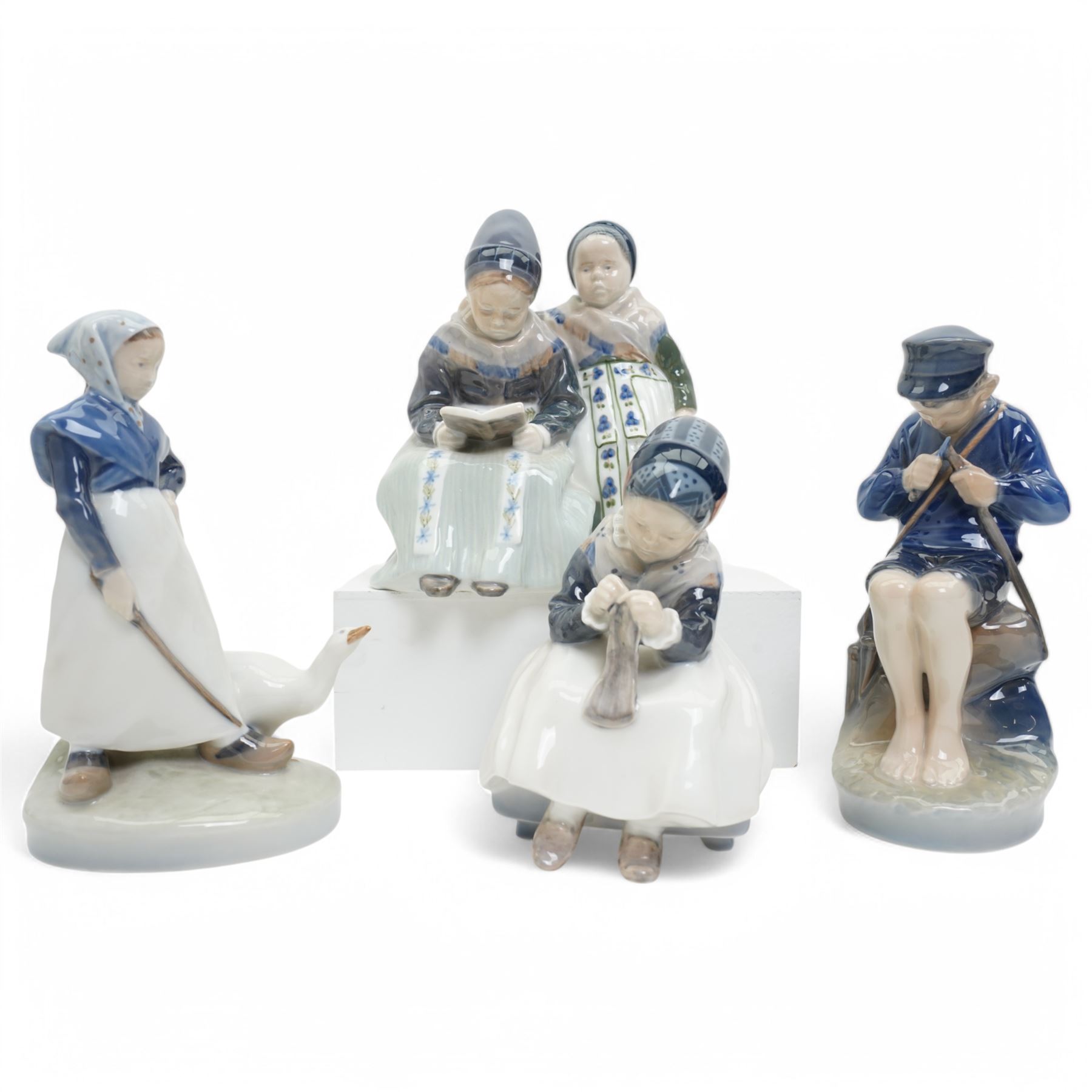 Four Royal Copenhagen figures, including Amager Girl Sewing no. 1314, Boy Whittling no. 905, Girl with Goose no. 528, and Amager Girls Reading no. 1395