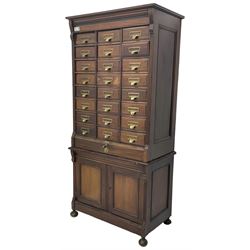 The Shannon Limited - late Victorian walnut filing cabinet, fitted with twenty-four small filing drawers, each with brass handle with label holder, fluted uprights, double cupboard below enclosed by two panelled doors, on turned feet, with brass plaque inscribed 'The Shannon, Limited, Ropemaker St. London, E.C.'