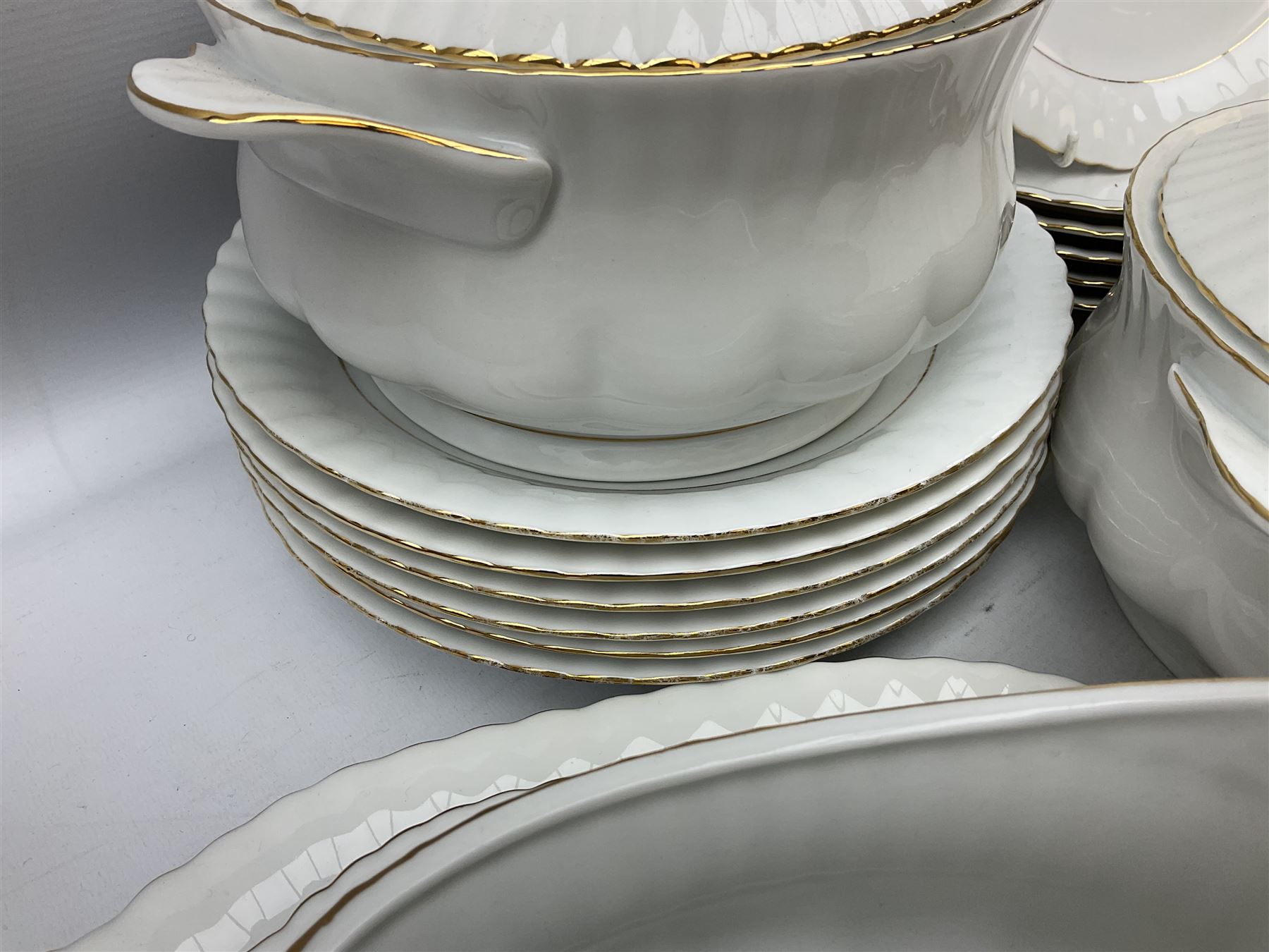 Chodziez Polish dinner wares decorated in white and gilt to include lidded twin handled tureens, bowls, plates etc