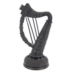 19th century Irish carved bog oak model of a harp, detailed with fluting, diamond cuts and shamrocks, upon a turned circular base, H29cm
