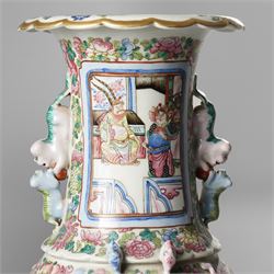 Large pair of 19th century Cantonese famille rose vases, each painted with various courtly scenes, including a display of warriors fighting on horseback before an official and his attendants, double Buddhist lion handles and applied at the shoulders with chilong, the lower band painted with Greek key motif, H58cm (2)
