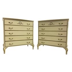 Pair French design cream and parcel-gilt chests, fitted with five drawers with chamfered uprights, decorated with applied bellflowers and central garland, raised on cabriole feet
