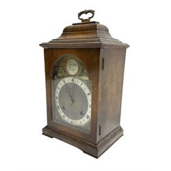 Imperial - English 1950s walnut and mahogany 8-day veneered mantle clock in an18th century-style case, with an inverted bell top and handle, break arch brass dial with a matted centre, silvered chapter ring with roman numerals and trefoil steel hands, cast spandrels and silvered Tempus Fugit boss to the arch, with a rack striking movement striking the hours and half hours on a gong. With pendulum and key.