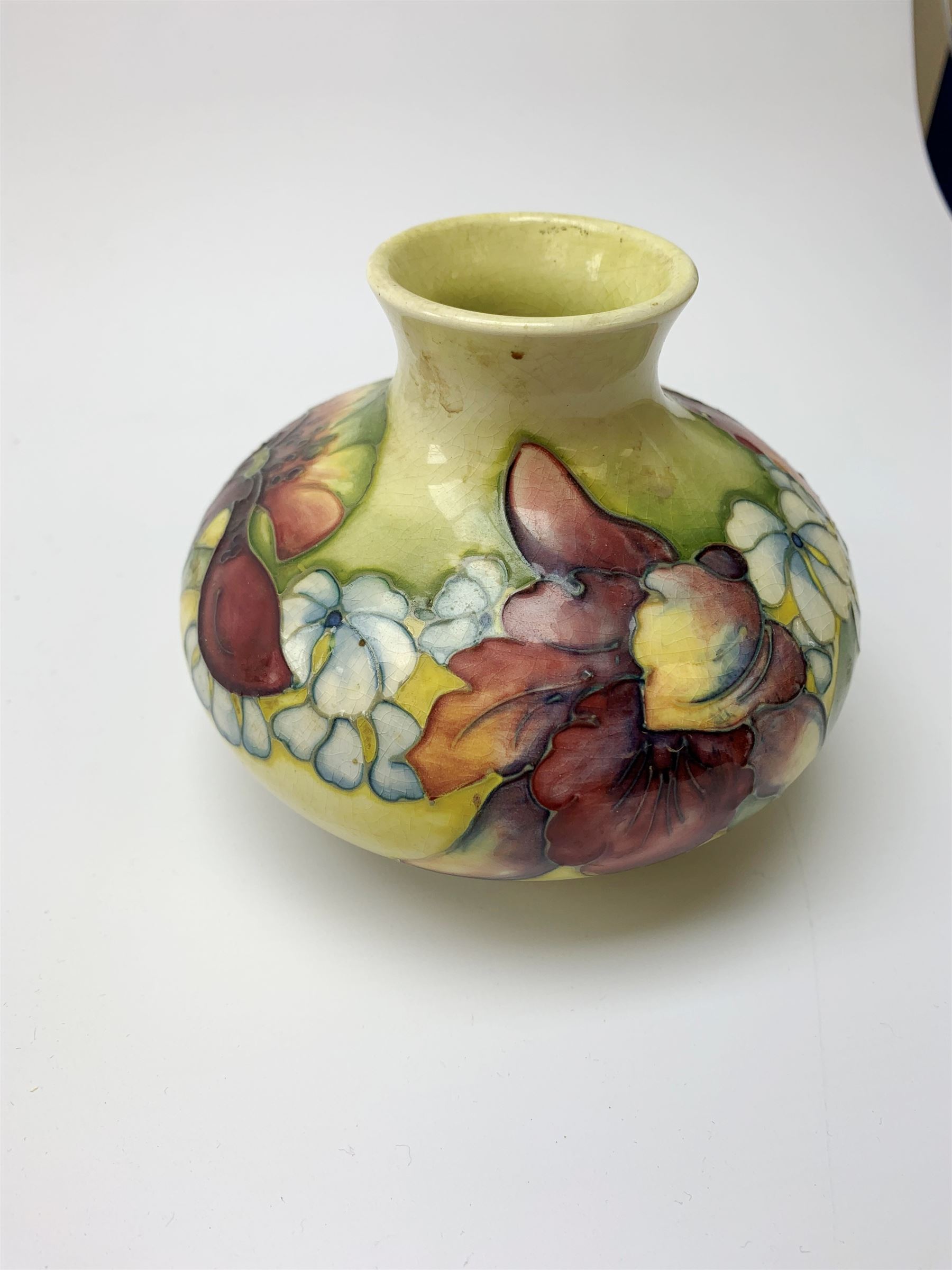 A Moorcroft vase, circa 1950, of squat bulbous form, decorated in the Orchid pattern upon a yellow glazed ground, with impressed and blue painted WM initials for Walter Moorcroft, H10.5cm. 
