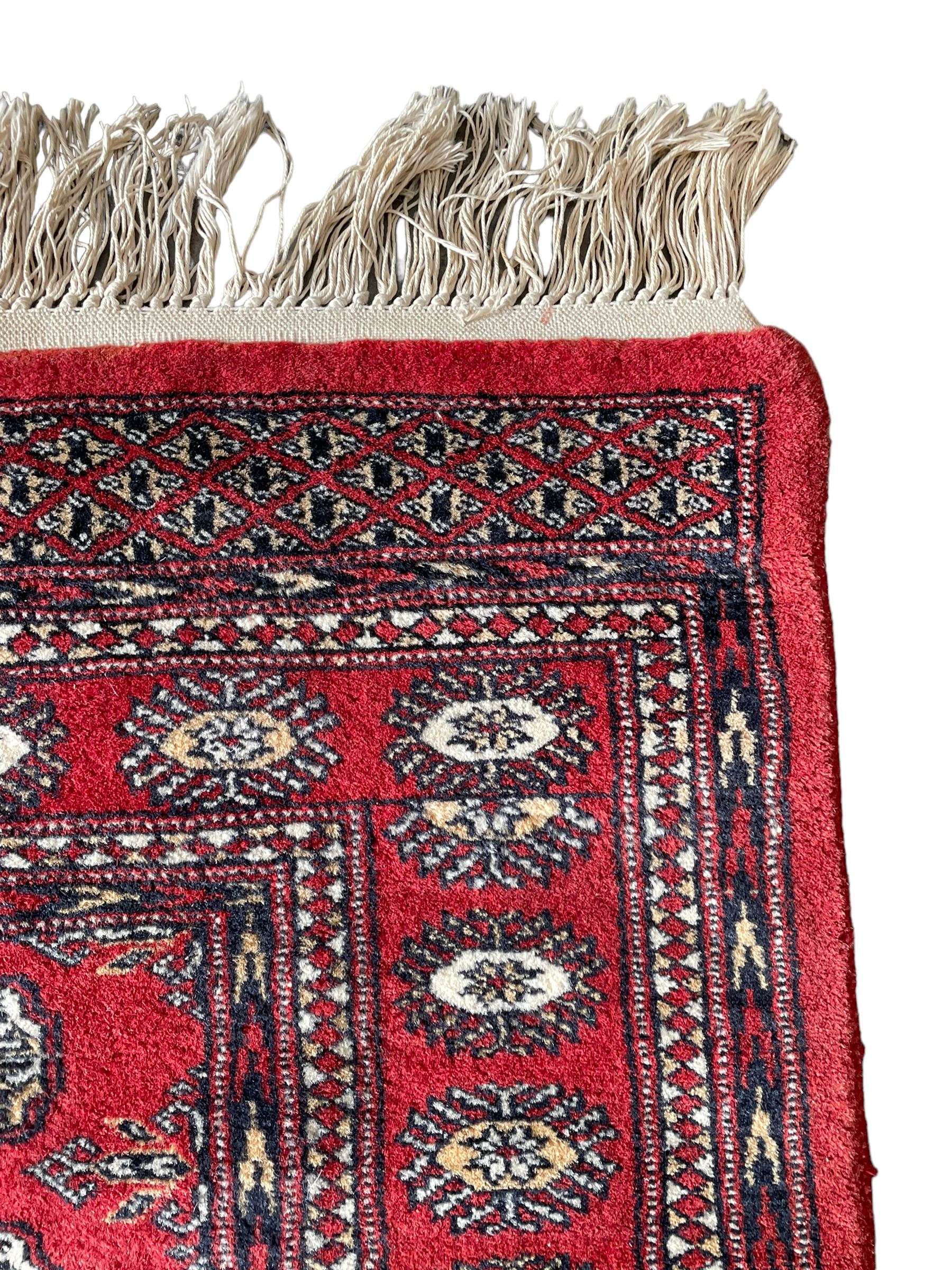 Tekke Bokhara red ground rug, decorated with two rows on Gul motifs, geometric design borders decorated with stylised floral motifs 