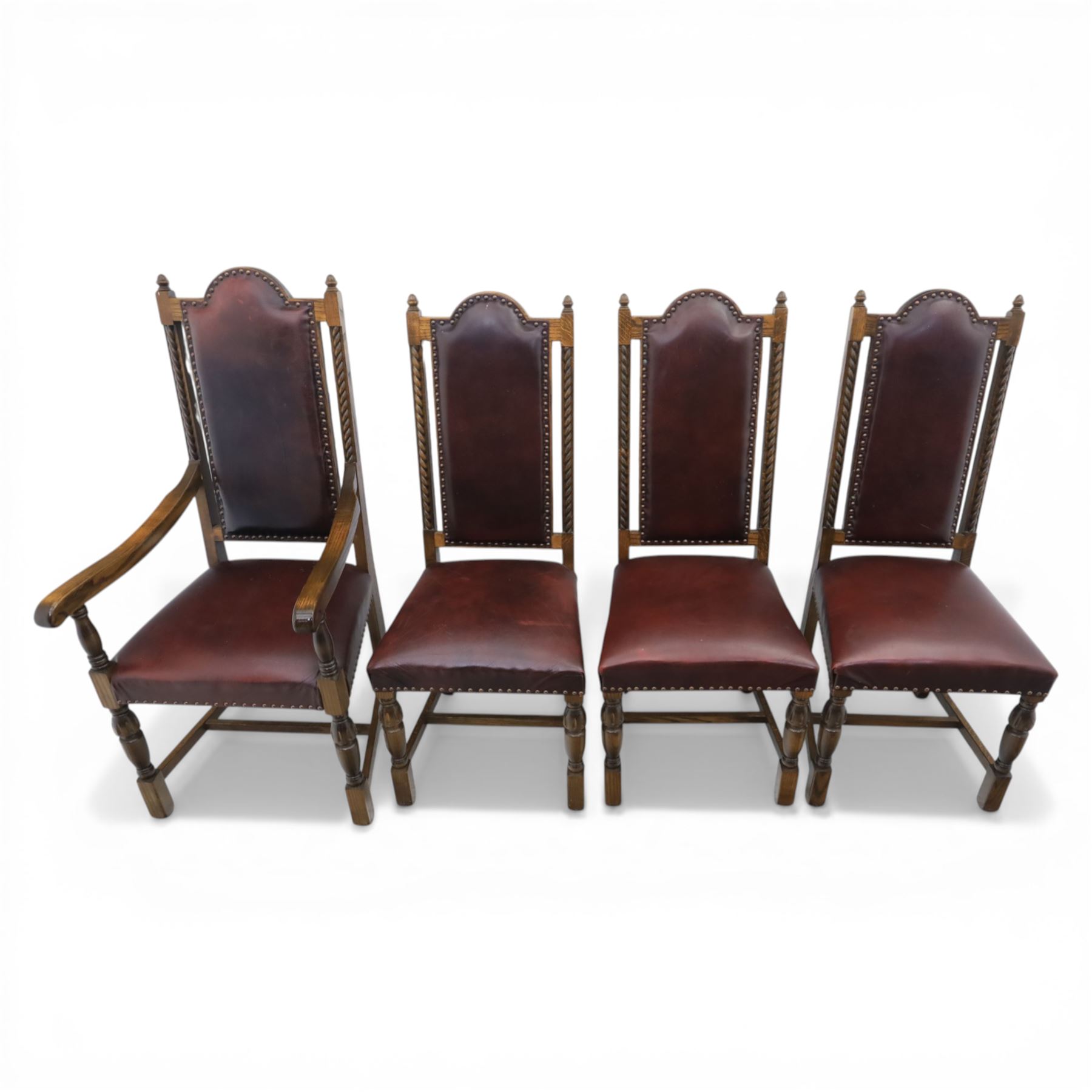 Carolean revival oak dining table and eight chairs (7+1), refectory table with rectangular boarded top and cleated ends, raised on shaped trestle end supports with central stretcher, accompanied by eight high-back chairs including a carver, leather upholstered panels and seats with studwork, on turned legs with stretchers.