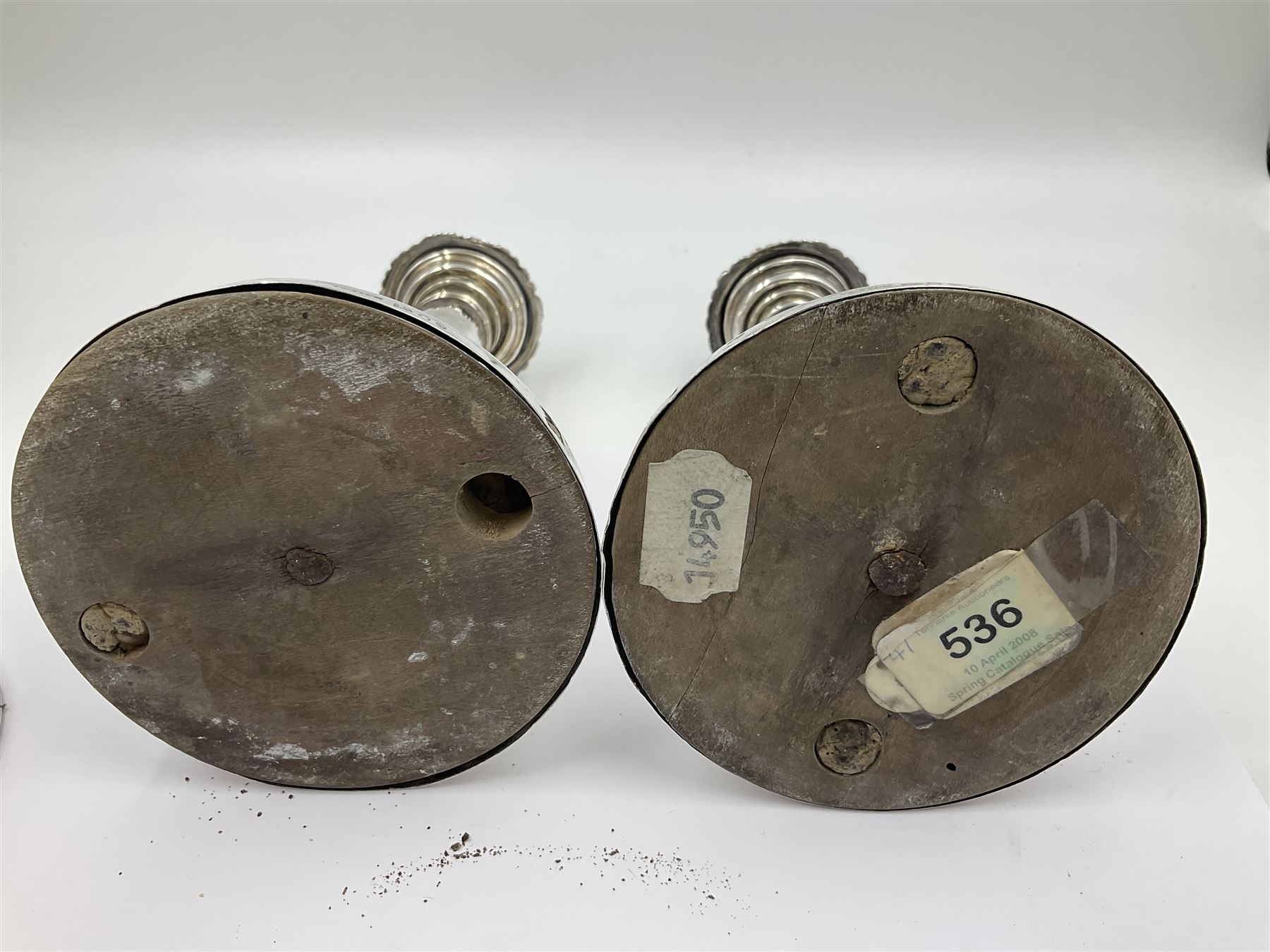 Four George III silver candlesticks, each upon knopped stem and weighted circular stepped foot, the foot and removable sconce repousse decorated with a band of flower heads, hallmarked to sconce and foot Thomas & John Settle, Sheffield 1820, H17.5cm