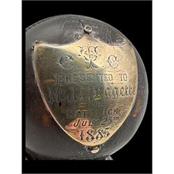 Victorian presentation 'Hat Trick' cricket ball, with applied silver shield cartouche presented to Mr J Hugger 1885, upon ebonised wooden stand