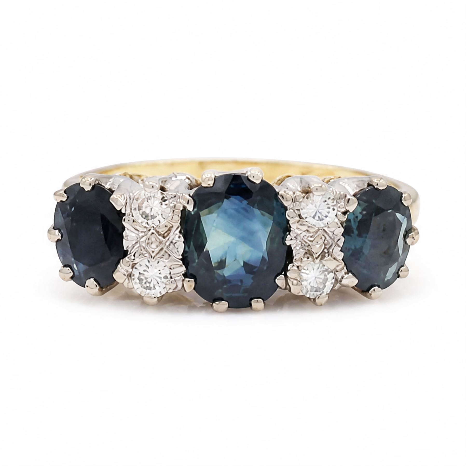 18ct gold sapphire and diamond ring, three graduating oval cut sapphires, the principal stone with two round brilliant cut diamonds set either side, London 1975, total sapphire weight approx 2.70 carat