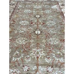 Pakistani ivory ground carpet, the field decorated with leaf branches, lotus flowers and roses, wide guarded border long leaves and stylised plant motifs