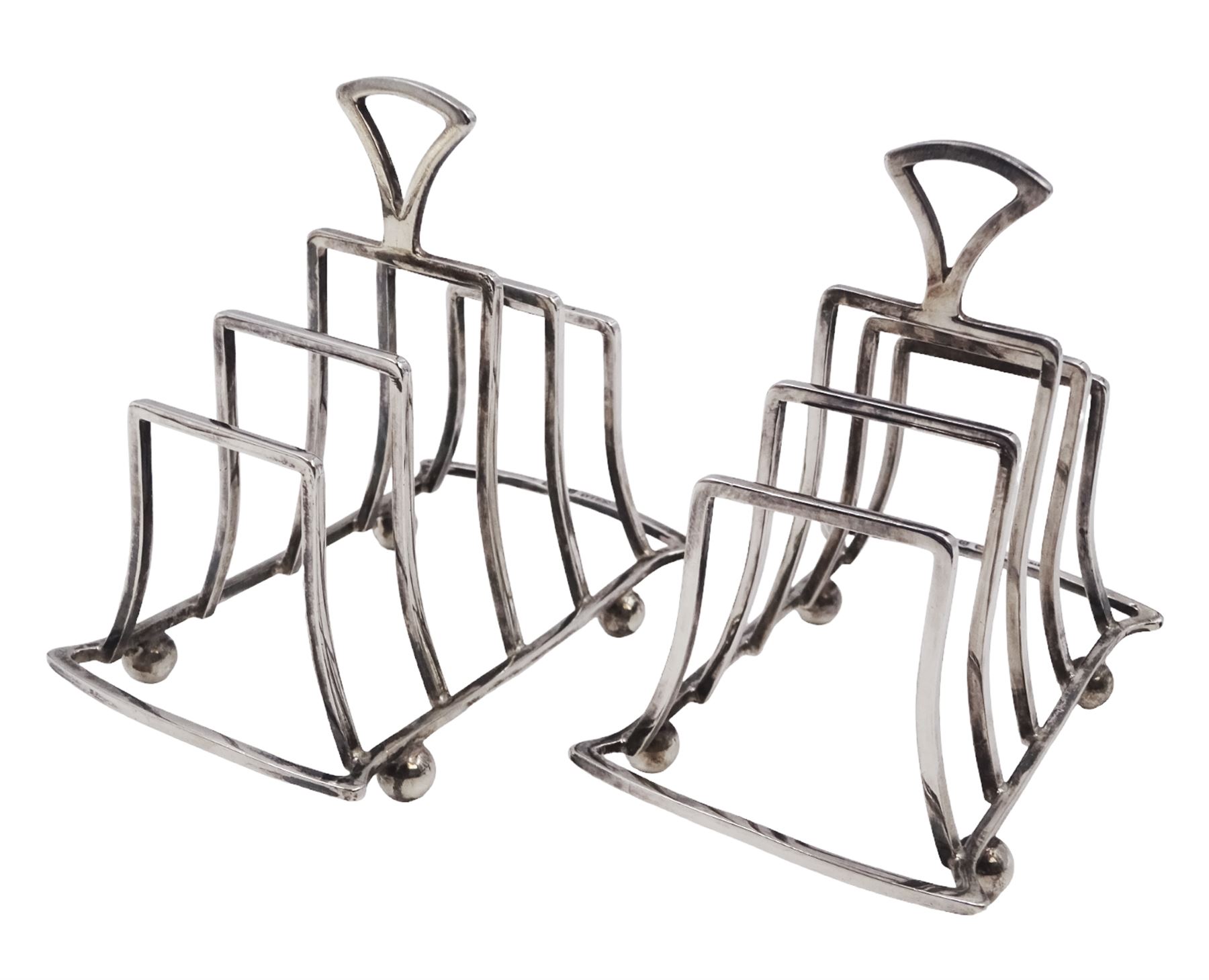 Pair of Art Deco silver five bar toast racks, each of graduating geometric form, with loop handle, upon four bun feet, hallmarked G Unite & Sons & Lyde Ltd, Birmingham 1928, H9cm