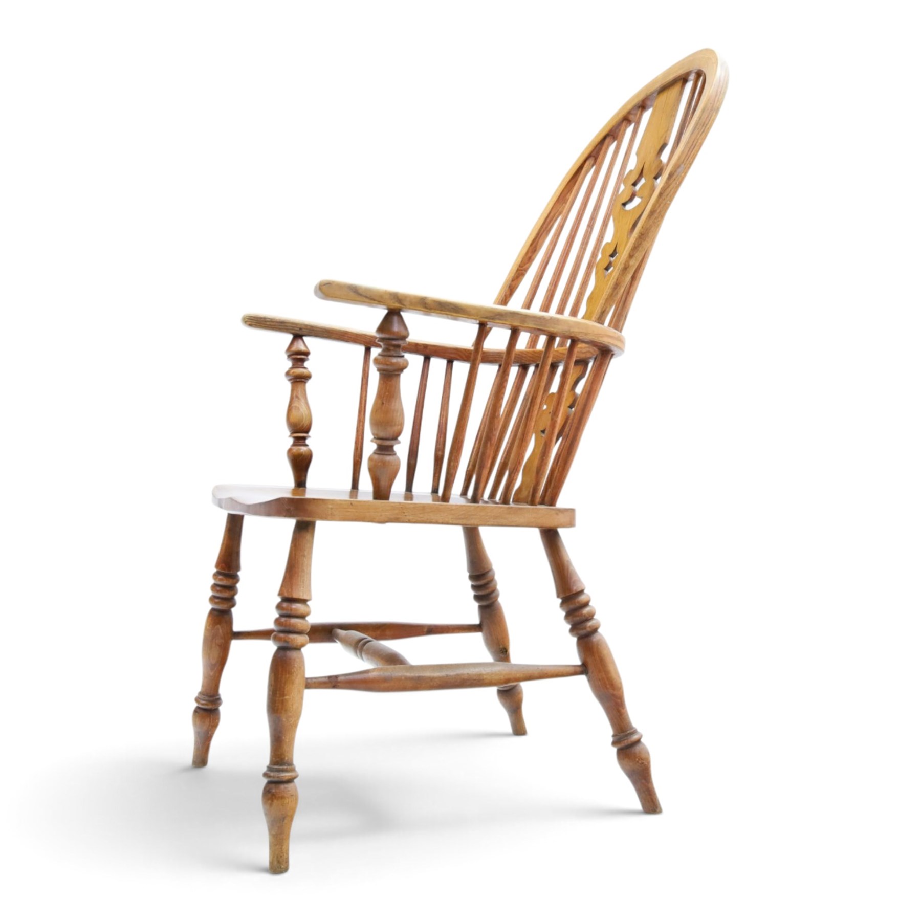 19th century elm Windsor armchair, with central pierced splat, flanked by spindles, dished seat, raised on turned supports united by H-stretcher
