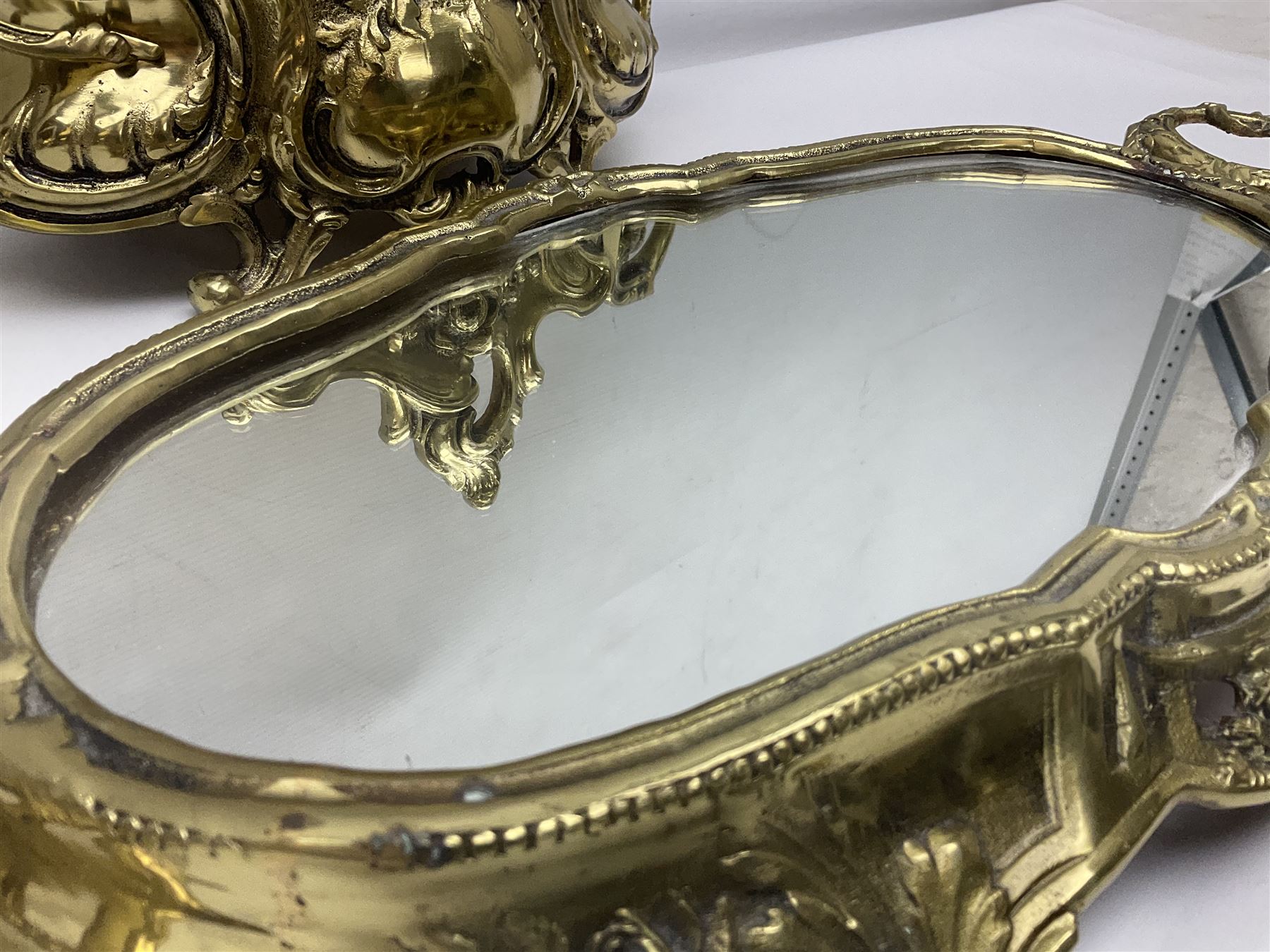 Ornate brass centrepiece, with twin handled vase upon a mirrored base, with floral and scrolling decoration, H23cm 