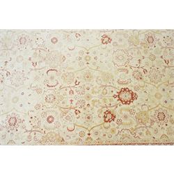 Modern Pakistani Oushak style wool hand-knotted carpet,  ivory field with an all-over scrolling floral vine design in soft tones of madder red and pale gold, enclosed by a conforming border, with cotton fringe ends  
