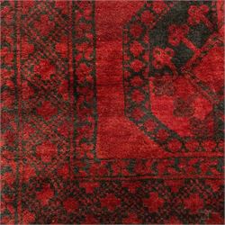 Turkmen Bokhara carpet, with a deep red field and repeating rows of black gul motifs, within multiple geometric borders