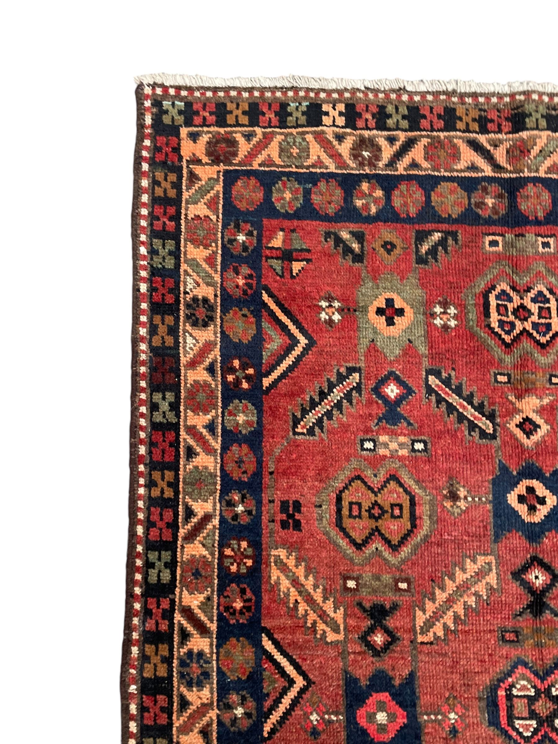 Near pair of Persian Azerbaijan red ground runners, each rug decorated with Nazarlik and stylised leaf motifs, enclosed with three band border decorated with flower heads and geometric motifs 

406cm x 99cm 
409cm x 102cm
