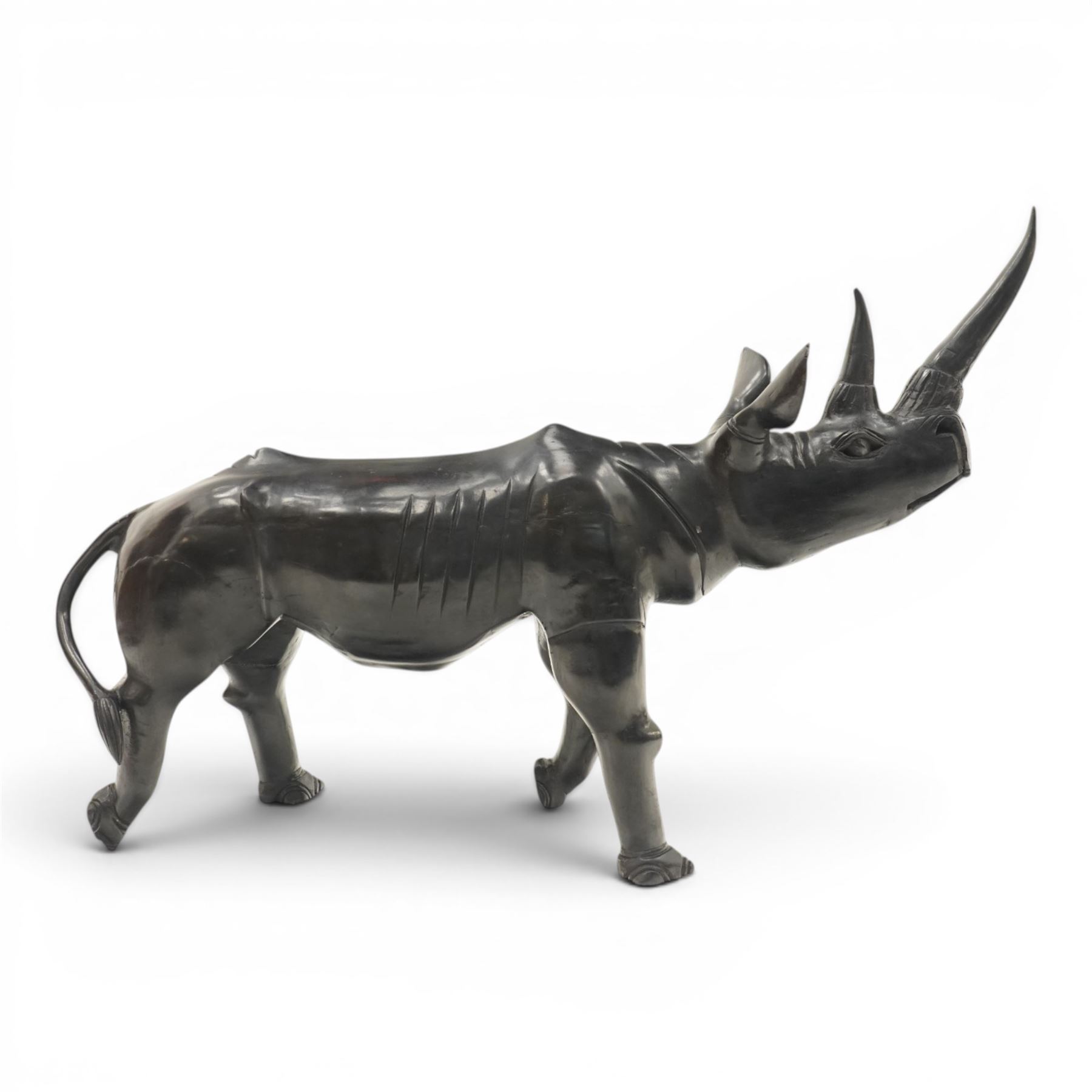 African carved hardwood ebonised figures of a rhinoceros and hippopotamus, each with stylised incised detail and polished dark finish, largest H 61cm, W 91cm)
