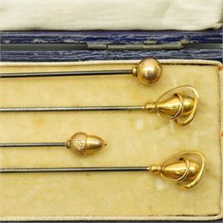 Four early 20th century 9ct gold mounted hat pins including an acorn, ball and cased pair by Charles Horner