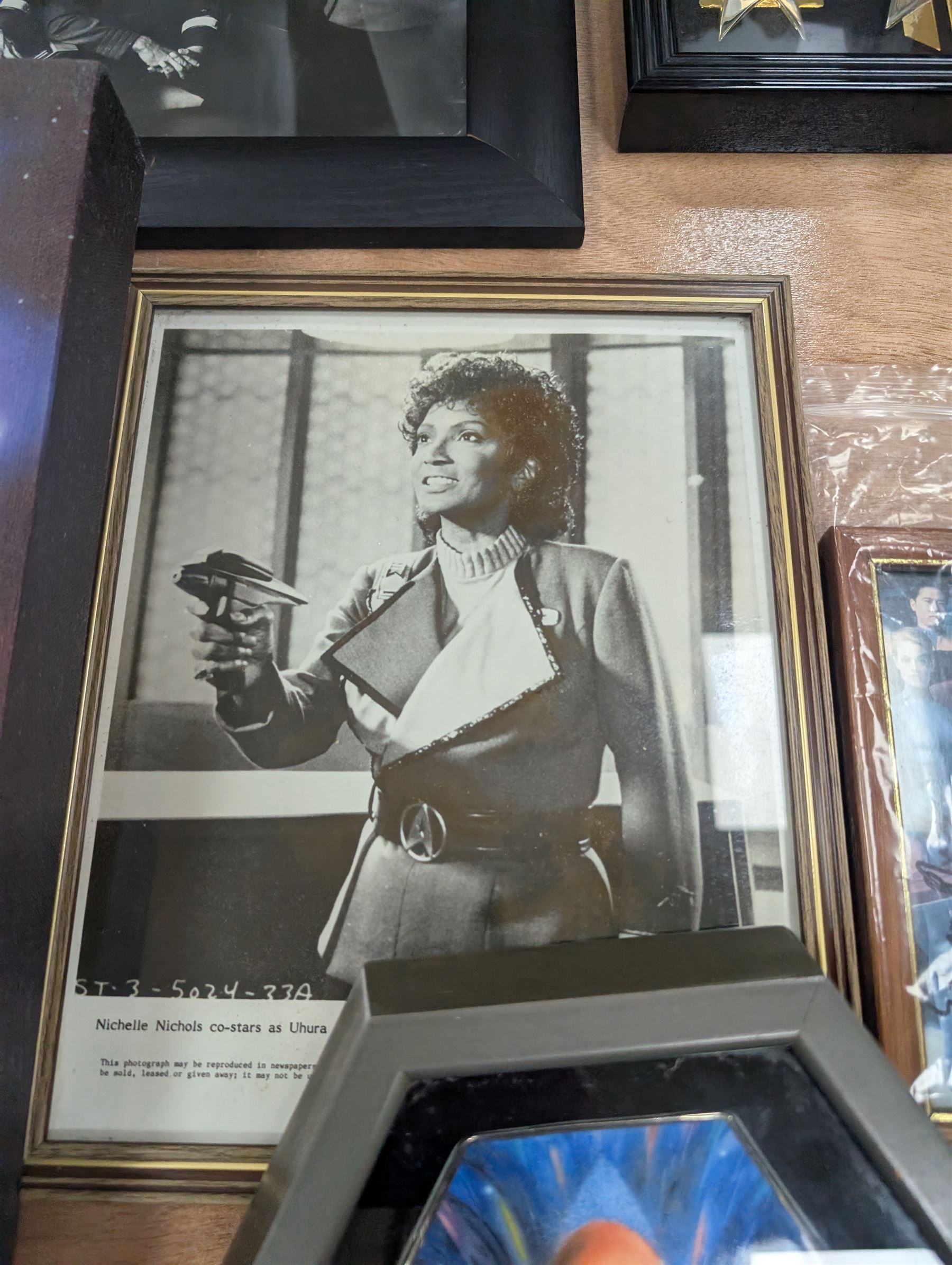 Collection of Star Trek The Next Generation and Deep Space Nine memorabilia, including two limited edition signed Star Trek Deep Space Nine photographs, commemorative porcelain plaque, insignias, Encounter at Farpoint pewter plaque, signed photograph of the Voyager crew, two signed copies of Convergence and a signed War & Madness graphic novel, canvas prints and other signed photos, together with Star Wars Ray Park (Darth Maul) signed photograph, UFO and Buck Rogers memorabilia