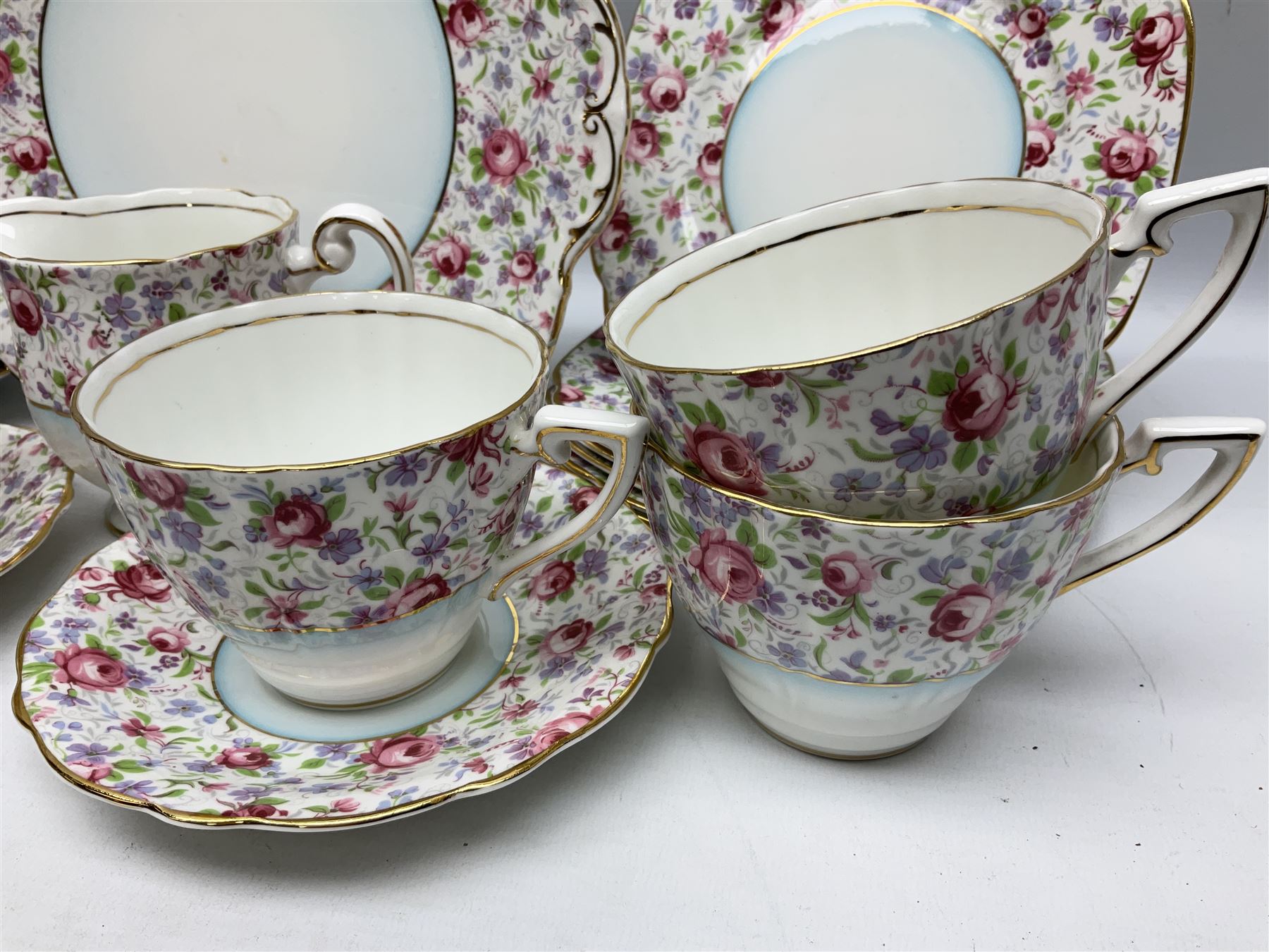 Windsor tea service for six decorated with blooming pink roses and purple flowers amongst foliage