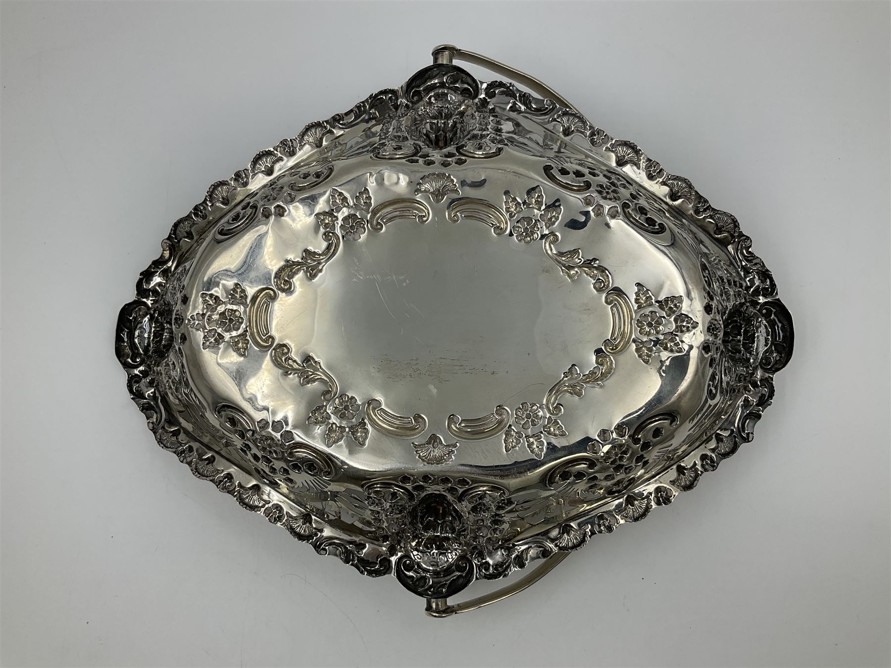 Edwardian silver swing handled basket, of navette form, with four repousse lion masks to each corner and with pierced and embossed floral, scroll and shell decoration to sides, base and handle, hallmarked Charles Horner, Birmingham 1906, height including handle H20cm