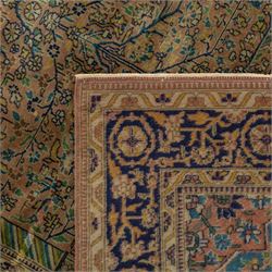 Antique Persian rug, with central tree of life design on a camel field, enclosed by dark blue floral border, with green, blue and ochre detail throughout