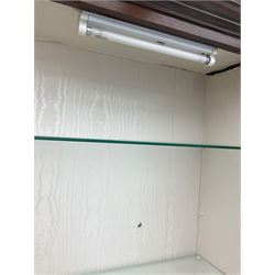 Mahogany display cabinet with hidden compartment, projecting cornice over single glazed door enclosing glass shelves, double panelled cupboard below, the interior with button releasing sliding back compartment, on bracket feet