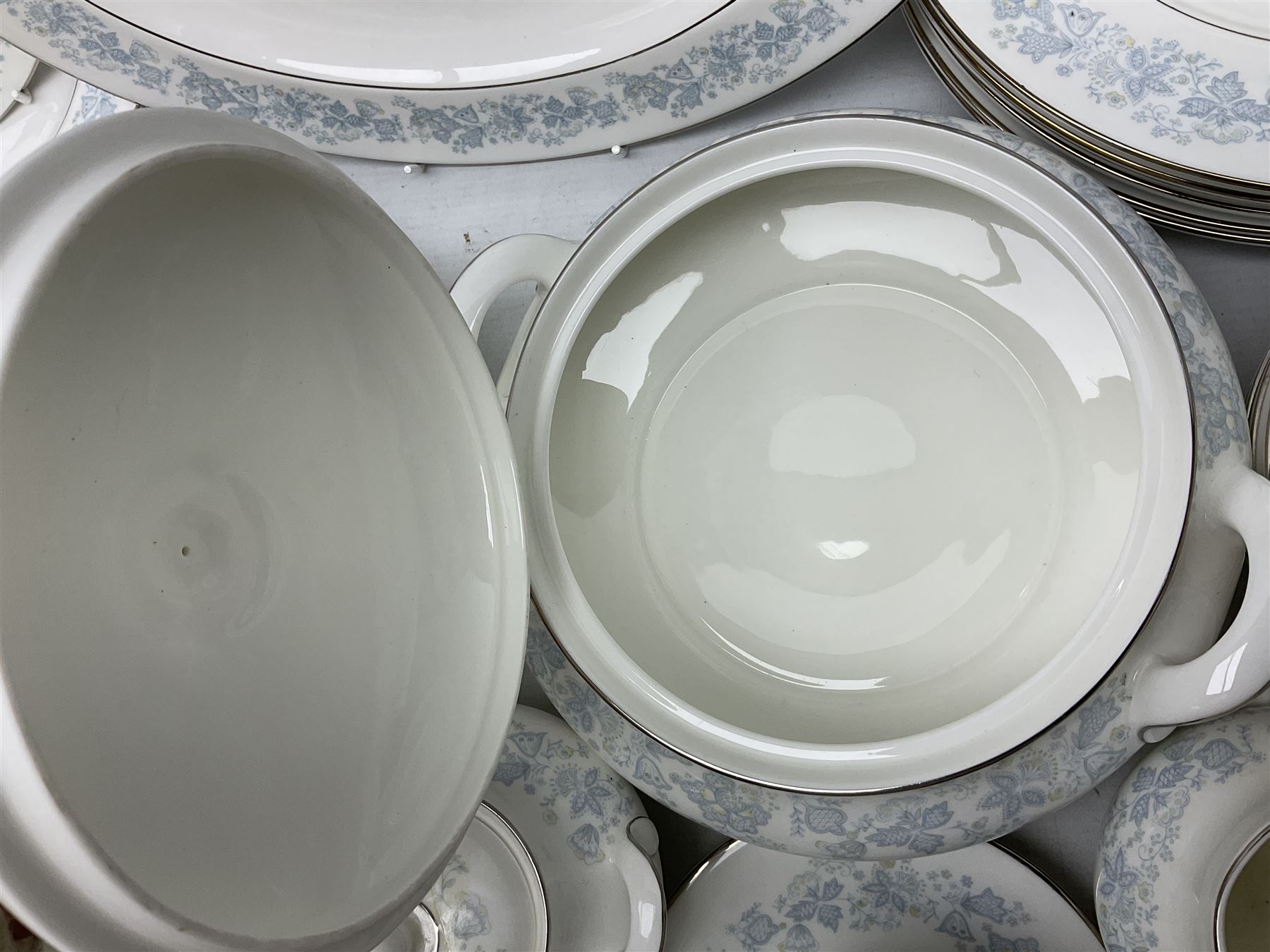 Royal Doulton tea and dinner wares in the Meadow Mist pattern, no H5007, comprising seven dinner plates, eight side plates, two lidded tureens, two jugs, lidded sucrier, oval serving dish, six teacups, seven saucers, seven tea plates and large saucer
