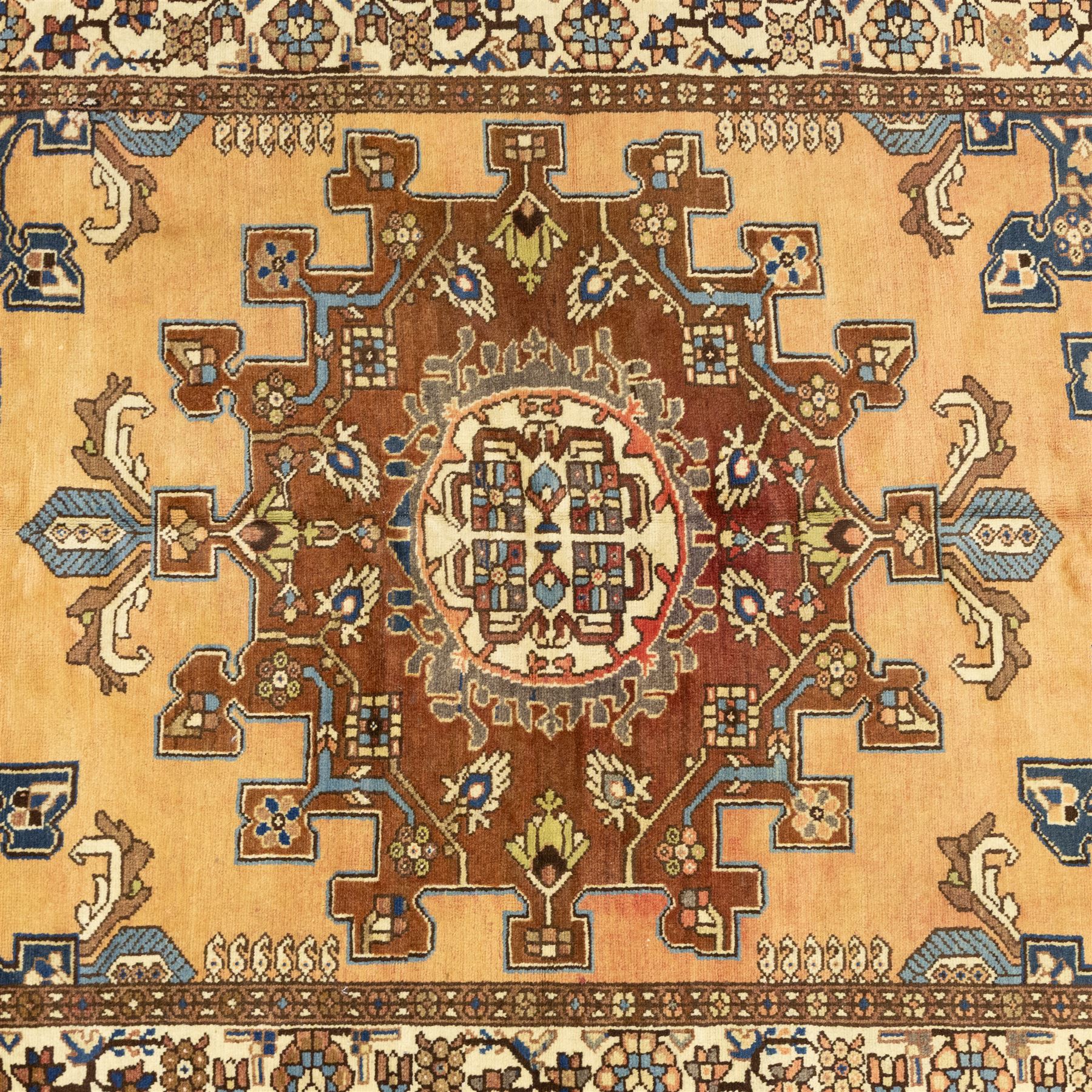 North West Persian Tafresh hand-knotted rug, pale apricot field with central stepped medallion enclosing stylized floral and angular motifs framed by indigo spandrels and multiple stylized floral borders, cotton fringe ends 