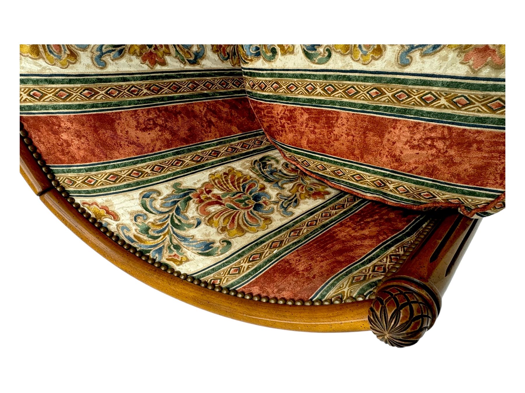 Pair of cherry wood framed tub-shaped armchairs, upholstered in striped floral fabric with brass stud trim, carved walnut frame with fluted supports capped with pinecone finials, on turned feet